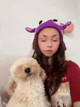 a woman wearing a purple hat and a red shirt with the word hero on it