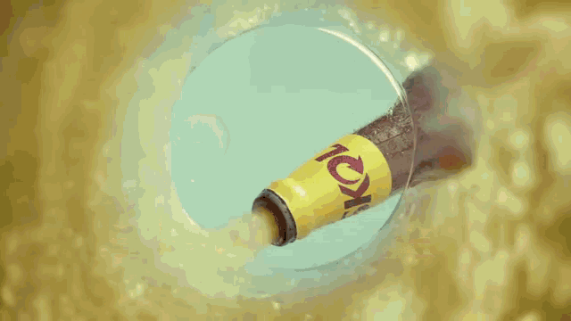 a can of skol sits on a table next to a glass of skol
