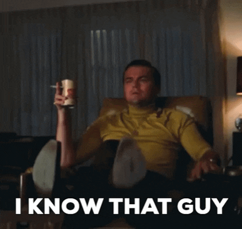 a man is sitting in a chair and pointing at something with the words " i know that guy " behind him