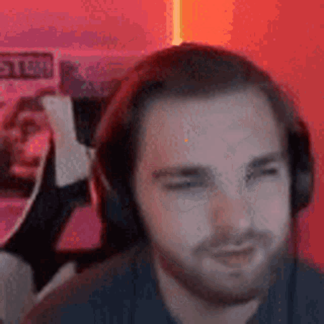 a man with a beard wearing headphones is sitting in a chair .