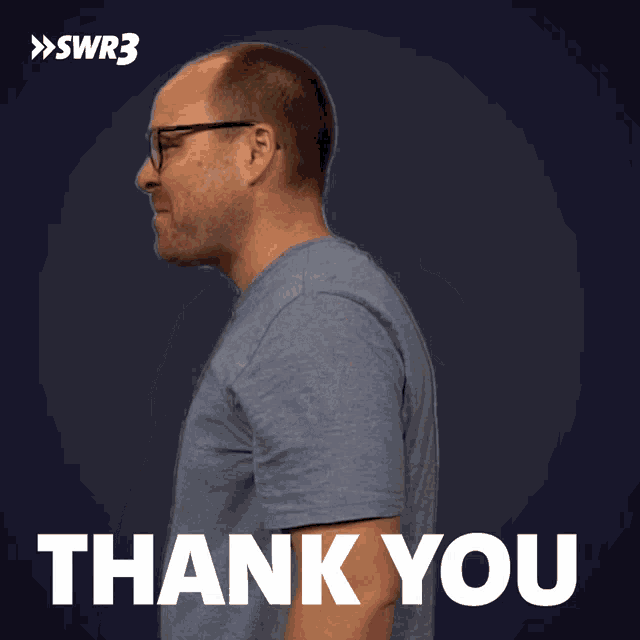 a man is giving a thumbs up in front of a sign that says thank you