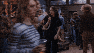 a group of people are dancing in a room with a sign that says ' a few dollars ' on it