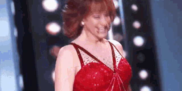 a woman in a red dress is standing on a stage .