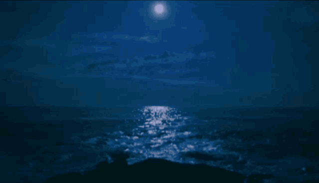 a full moon shines brightly over a body of water