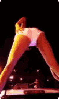 a woman 's butt is visible in front of a car with a third brake light