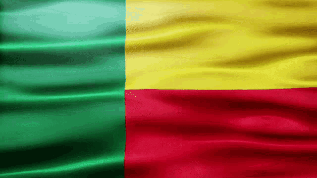 a green yellow and red flag is being blown by the wind