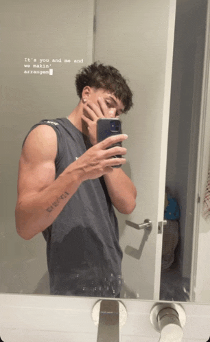 a man taking a picture of himself in a bathroom mirror with the words it 's you and me