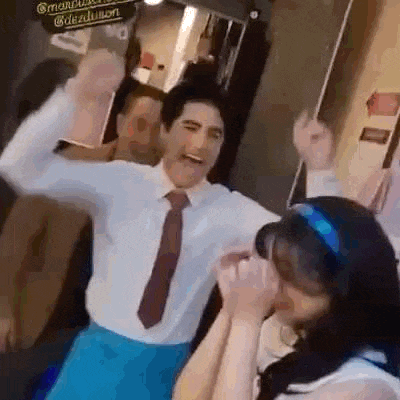a man in a suit and tie is dancing with a woman in a headband .