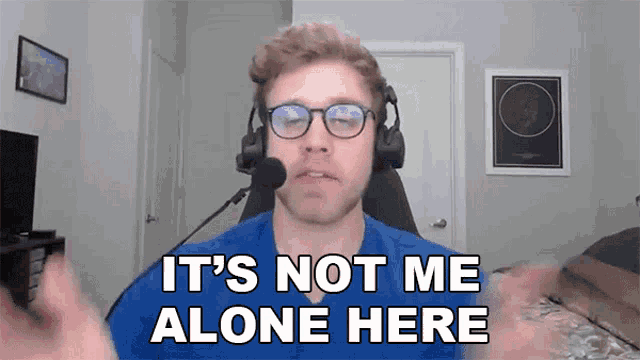 a man wearing headphones and glasses is saying it 's not me alone here