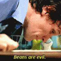 a man in a blue shirt and tie is eating beans and says beans are evil