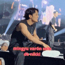 a man is sitting on a stage with the words mingyu varon solo de nikkl written on the bottom
