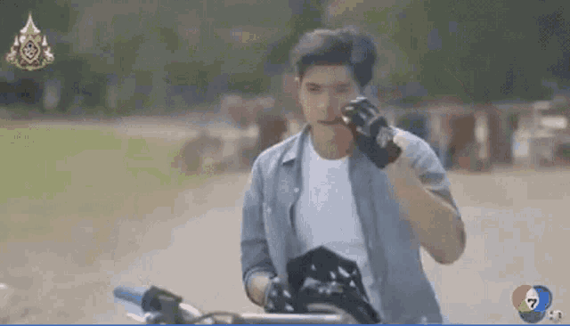 a man wearing gloves is standing next to a motorcycle