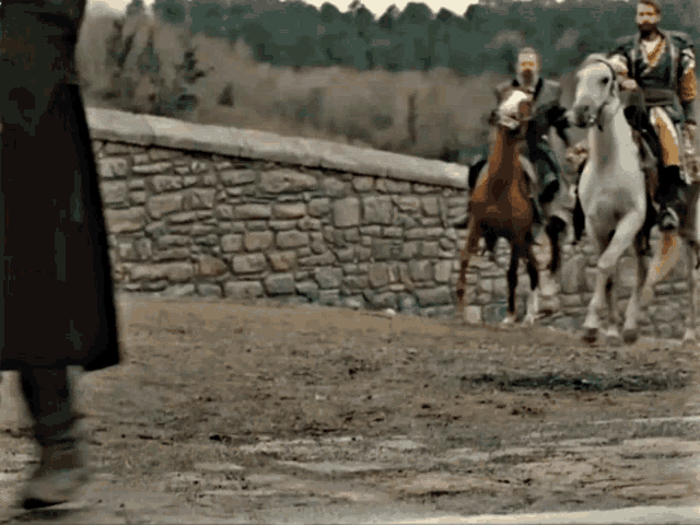 a group of men are riding horses in a field .