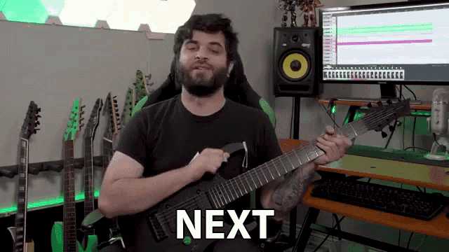 a man is playing a guitar in front of a computer and the word next is on the screen