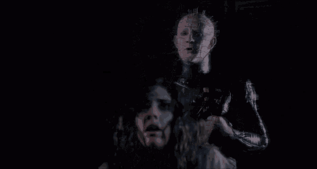 a woman with blood on her face is standing in front of a door .
