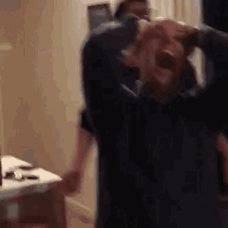 a blurry picture of a man holding another man 's head while screaming .