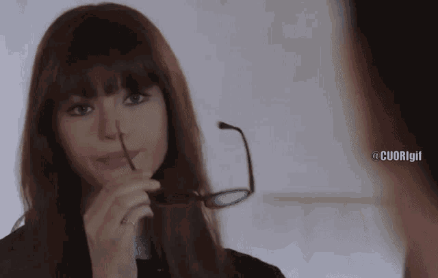 a woman holding a pair of glasses in front of her face with cuorigirl written on the bottom