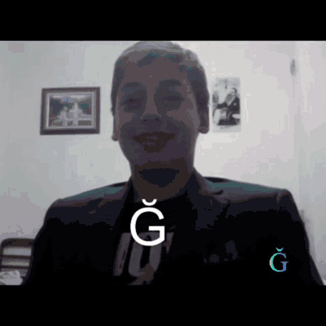 a young man in a suit says the letter g