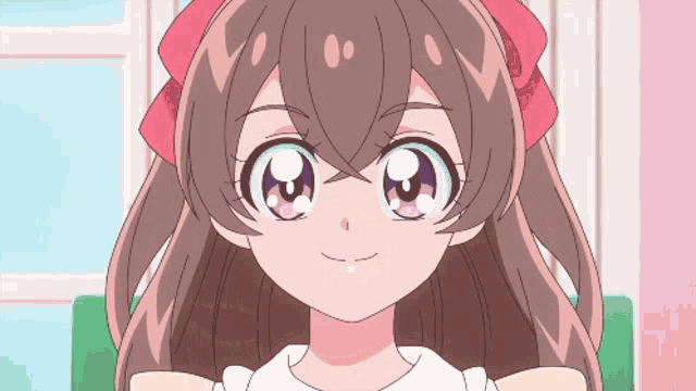a close up of a girl 's face with a pink bow in her hair