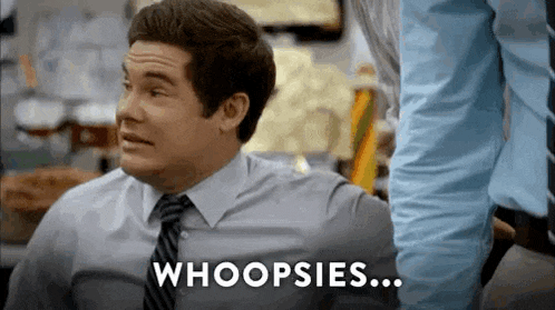 a man in a suit and tie is making a funny face and says whoops .