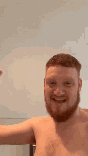 a shirtless man with a beard flexing his muscles