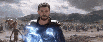 a man with a beard is standing in a field holding a lightning bolt