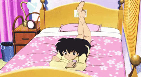 a girl is laying on her stomach on a bed with her legs up