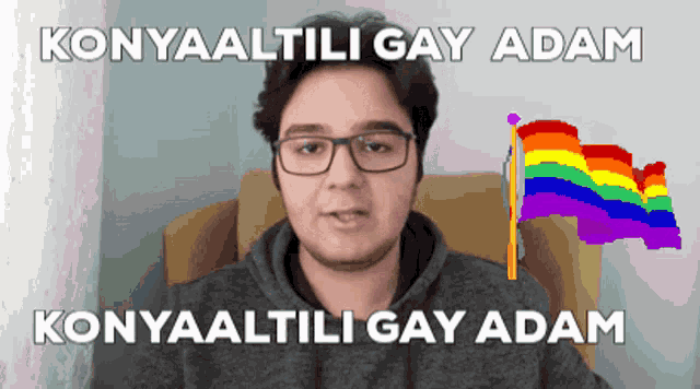 a man with glasses is sitting in a chair with a rainbow flag behind him and the words konyaaltili gay adam