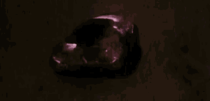 a close up of a rock with a light coming out of it in the dark .