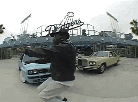 a man is jumping in the air in front of dodgers stadium