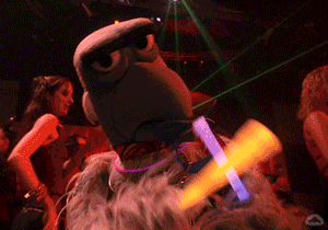 a stuffed animal is dancing in a club with glow sticks