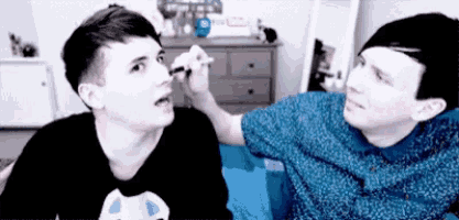 two young men are applying makeup to each other 's faces .