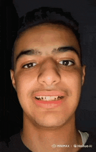 a close up of a young man 's face with a beard and a smile on his face .