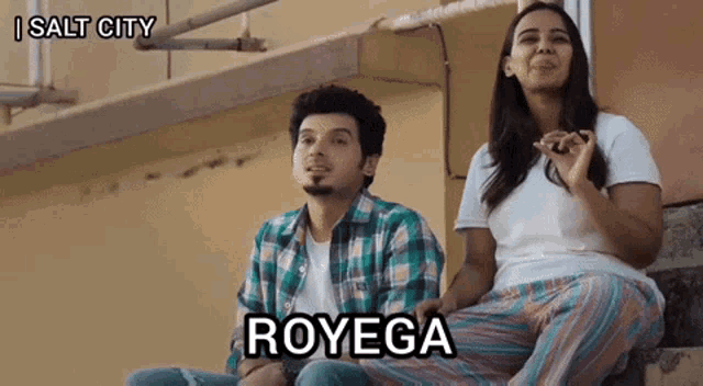 a man and a woman are sitting on a set of stairs and the woman says royega