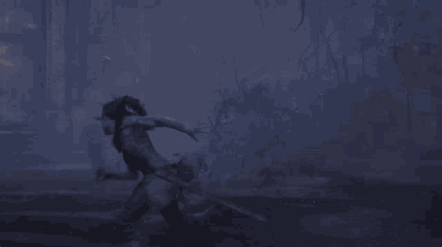 a person walking through a dark forest with a sword in their hand
