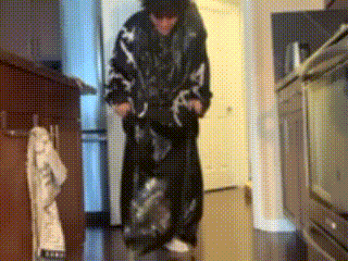 a person is standing in a kitchen wearing a black jacket