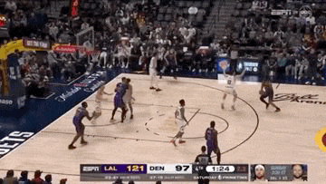 a basketball game is being played in a stadium with a crowd watching .