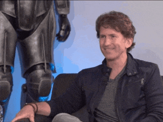 a man in a leather jacket sits in front of a statue