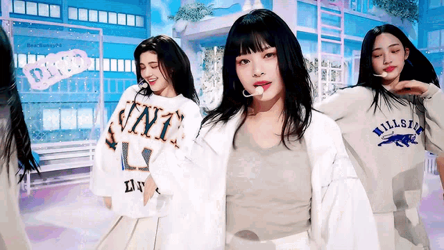 a girl wearing a shirt that says ' univ ' on it is dancing