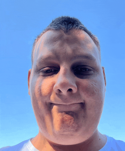 a man making a funny face with a blue sky in the background