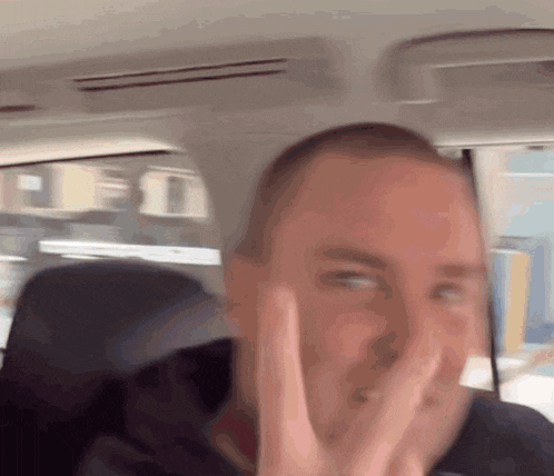 a man in a car making a peace sign with his hand