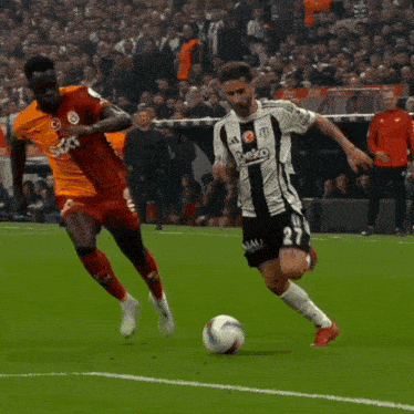 a soccer player wearing a black and white beko jersey kicks the ball
