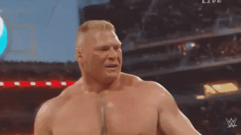 a shirtless wrestler is standing in front of a crowd in a stadium with the letters w on his chest