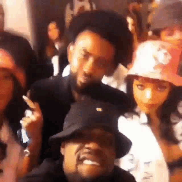 a group of people are posing for a picture and one of them is wearing a hat with the letter r on it