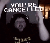 a man wearing headphones is holding up a sign that says ' you 're cancelled '