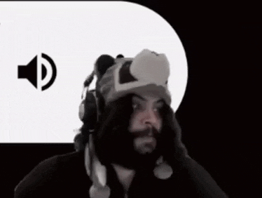 a man wearing a bear hat is making a funny face with his hands in front of a speaker icon .