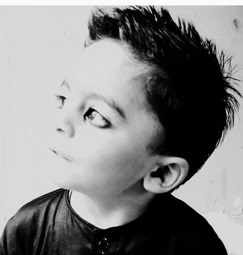 a black and white photo of a young boy