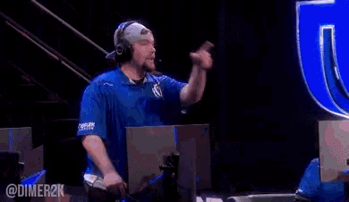 a man wearing headphones stands in front of a computer screen with the letters u on it
