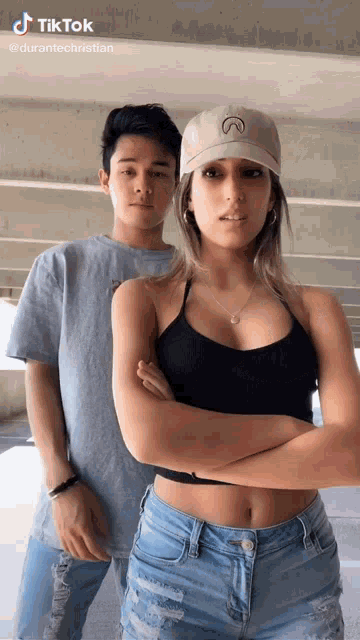 a man and a woman are standing next to each other with their arms crossed and a tiktok watermark above them