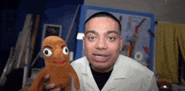 a man in a white shirt holds a stuffed animal with big eyes